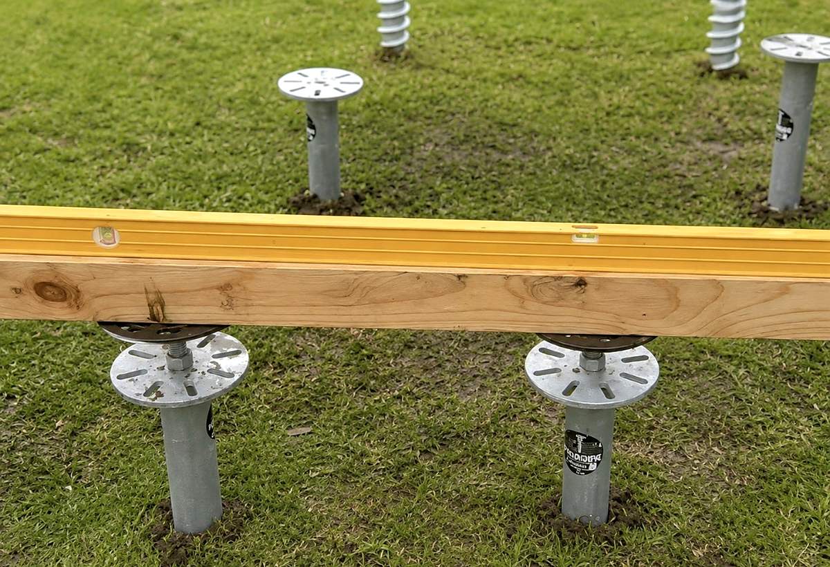 Timber bearer levelled across two galvanised screw pile head plates
