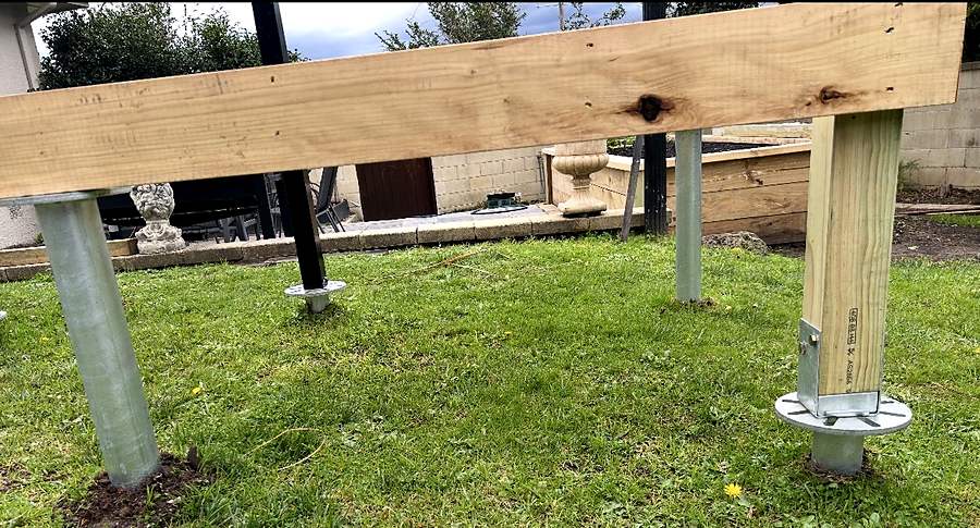 Galvanised screw pile running direct to a timber bearer beside a timber post in a galvanised bracket